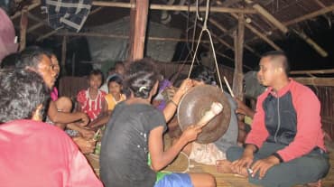Gruppe Indigener mit Trommel in einer Hütte
