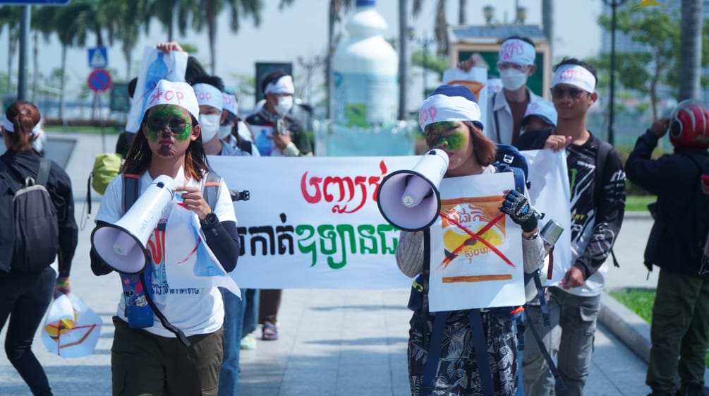 Eine Gruppe junger StudentInnen läuft mit Megafon und Plakaten durch eine Straße