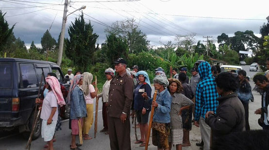 Bauernfamilien protestieren auf einer Landstraße auf Sumatra gegen die Abholzungen und Verhaftungen