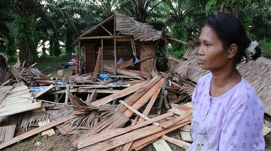 Eine Ureinwohnerin sitzt verstört vor den Trümmern ihres Hauses
