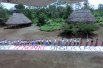 Die Indianer in einem Dorf im Amazonasregenwald richten sich mit einem Banner an die Öffentlichkeit: Dies ist unser Land.