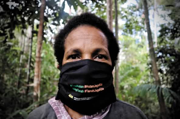 Papua-Frau mit Mundschutz "Schütz den Wald - der Wald schützt uns"