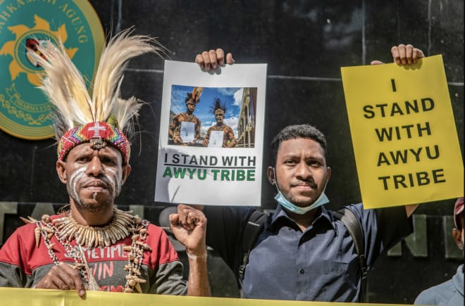 ein Papua und ein Indonesier halten Solidaritätsplakate