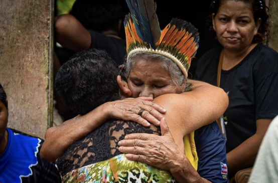 Eine Teilnehmerin der Trauerfeier umarmt Maria Muniz Tupinambá, die Schwester der erschossenen indigenen Führerin Maria de Fátima Muniz Pataxó („Nega“)