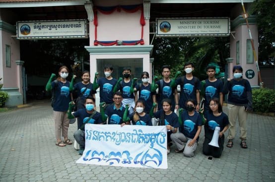 15 Jugendliche stehen und knien vor dem Gebäude des Tourismusministeriums und halten einen Banner in die Kamera. Dort steht: „Koh Kong Island soll ein Meeresnationalpark werden“