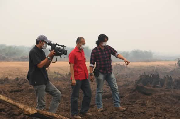 Feri Irawan mit Filmteam auf abgebrannter Fläche