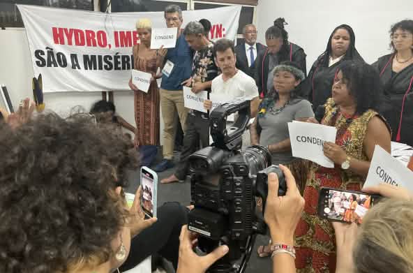 Eine Gruppe von zehn Personen, die das symbolische Gerichtsverfahren durchgeführt hat, wird mit einer Fotokamera und Handys gefilmt