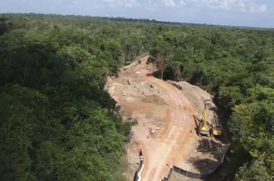 Luftaufnahme vom Bau der Bauxit-Pipeline im Regenwald mit von Baggern zerwühlter Erde und Rohrteilen
