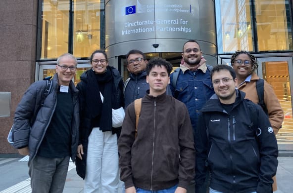 Gruppenfoto von 7 Personen vor dem Eingang eines Gebäudes der EU-Kommission in Brüssel