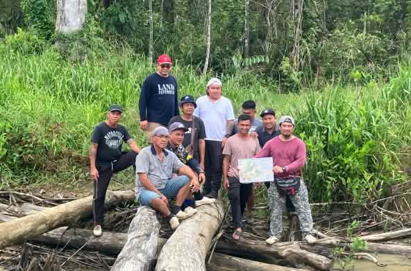 Indigene Sungai Seruas zeigen eine Karte, die sie und SADIA hergestellt haben.