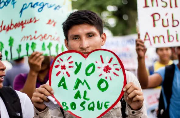 Ein Demonstrant in Iquitos, Peru, zeigt ein Herzplakat "Ich liebe den Wald" auf Demo gegen Abholzung für Kakaoplantagen