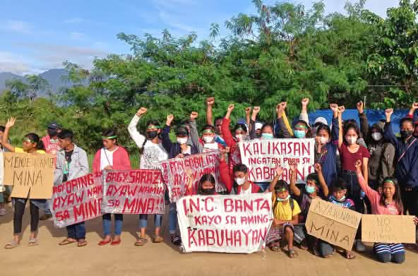 Junge Indigene demonstrieren, halten Plakate und strecken Arme und Fäuste hoch
