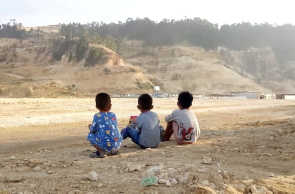drei Kinder blicken auf Sandabbau