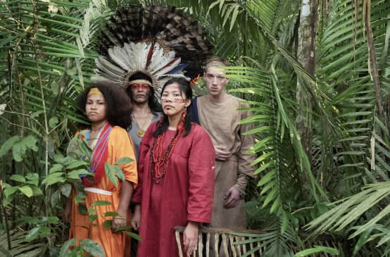 Schauspieler aus dem Theaterstück Antigone im Amazonas stehen im Regenwald
