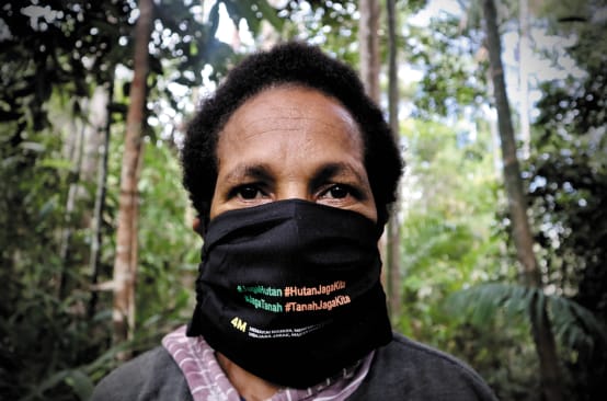 Papua-Frau mit Mundschutz "Schütz den Wald - der Wald schützt uns"