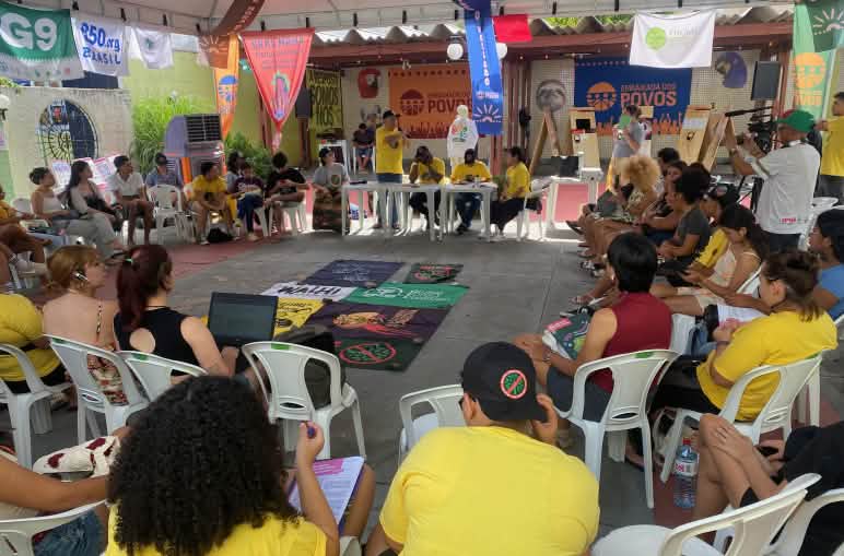 Etwa 30 Personen auf Stühlen bilden in einem Sitzungsraum einen Kreis