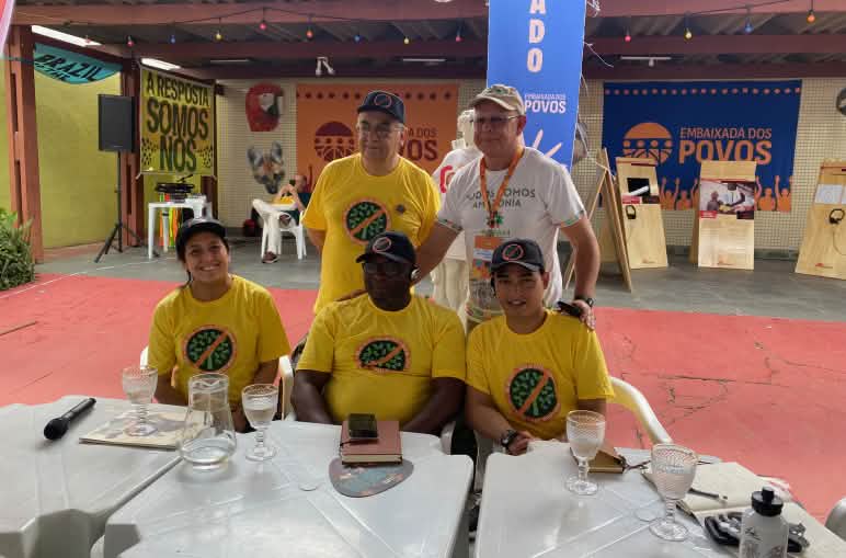 Gruppenfoto von fünf Personen hinter einem Podiumstisch