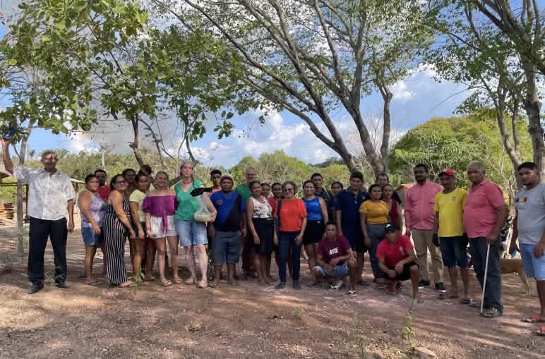 30 Personen haben sich zu einem Gruppenfoto unter Bäumen aufgereiht