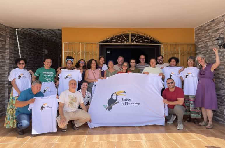 Gruppenfoto von 20 Personen mit einem Banner und T-Shirts mit dem Tukan-Logo des Vereins und der Aufschrift Salve a Floresta (Rettet den Regenwald)