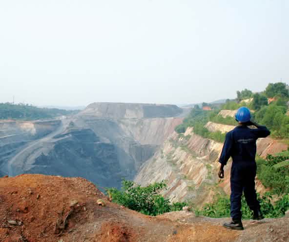 Ein Arbeiter sieht in eine große Tagebau-Mine