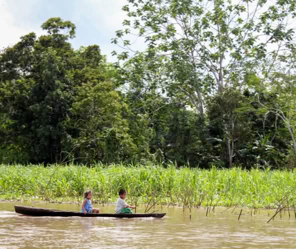 Zwei Kinder fahren auf dem Amazonas-Fluss Boot