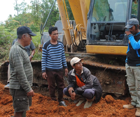 Wardian steht vor einem Bulldozer und diskutiert mit den Arbeitern