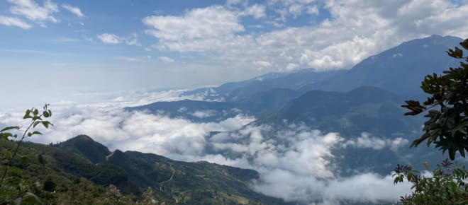 Berglandschaft mit weissen Wolken am Boden und oben am Himmel