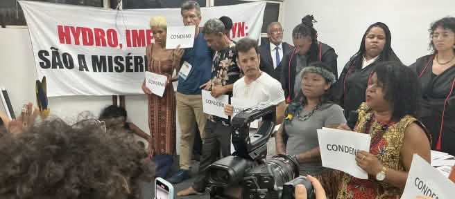 Eine Gruppe von zehn Personen, die das symbolische Gerichtsverfahren durchgeführt hat, wird mit einer Fotokamera und Handys gefilmt