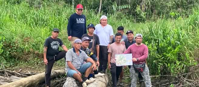 Indigene Sungai Seruas zeigen eine Karte, die sie und SADIA hergestellt haben.