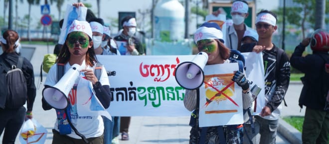 Eine Gruppe junger StudentInnen läuft mit Megafon und Plakaten durch eine Straße