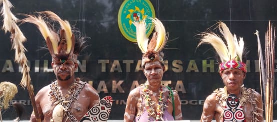 Indigene Awyu verteidigen ihren Regenwald vor Gericht (© Pusaka) Drei Indigene in traditioneller Kleidung