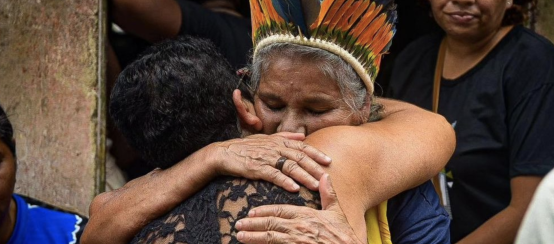 Eine Teilnehmerin der Trauerfeier umarmt Maria Muniz Tupinambá, die Schwester der erschossenen indigenen Führerin Maria de Fátima Muniz Pataxó („Nega“)