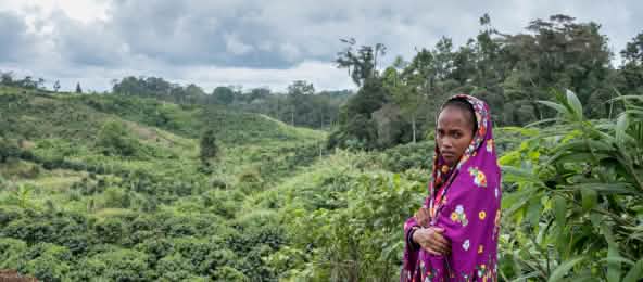 Im Dezember 2017 wurden der Ehemann und der Vater von Mirivic Tarsila Danyan von der Armee getötet, weil sie das Land der Gemeinde gegen die Ausweitung der Kaffeeplantagen auf den Philippinen verteidigten. (© Thom Pierce/Guardian/Global Witness/UN Umwelt) Umhüllt von einen Tuch steht Mirivic 'Tarsila' Danyan auf einer Rodung im Regenwald auf den Philippinen