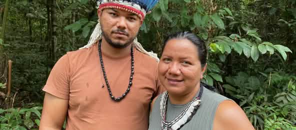 Porträt einer indigenen Frau mit Federhalskette rechts und eines jungen indigenen Mannes mit Federkrone rechts