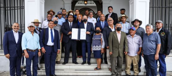 Die Allianz zur Verteidigung des Santa-Maria-Flussgebietes zusammen mit dem Präsidenten von Panama, Laurentino Cortizo Cohen, am Eingang des Präsidentenpalastes (© Yoel Pérez) Eine Gruppe von ca. 20 Personen mit dem Präsidenten Panamas in der Bildmitte präsentiert das unterzeichnete Gesetz am Eingang des Regierungspalastes