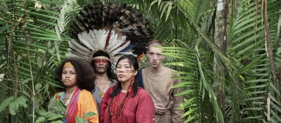 Schauspieler aus dem Theaterstück Antigone im Amazonas stehen im Regenwald