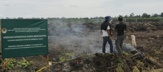 Wildtier-Schutzgebiet Singkil (© Junaidi Hanafiah) zwei Männer auf Rodung und Schild "Wildlife Reserve"