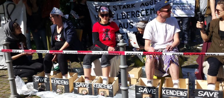 Protest vor der Stadthalle Heidelberg: Aktivisten mit einbetonierten Füßen Protest gegen HeidelbergCement: Aktivisten betonieren ihre Füße ein