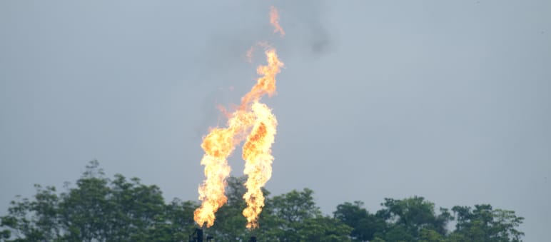 Aus zwei in den Himmel ragenden Rohren von Gasfackeln der Ölindustrie steigen Flammen auf