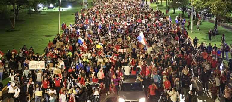 Ein Demonstrationszug mit Tausenden Menschen zieht über eine Straße in der Hauptstadt