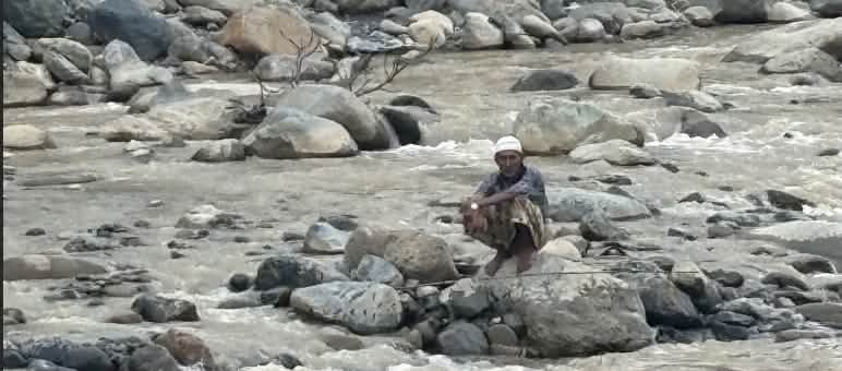 Mann auf Stein im Fluss