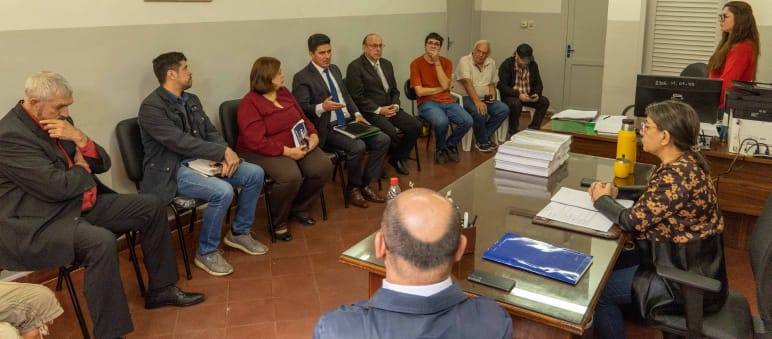 Szene aus der Petitionsübergabe und des Gesprächs: 8 Menschenrechtler sitzen der Präsidentin des INDI und zwei Mitarbeitern:innen gegenüber