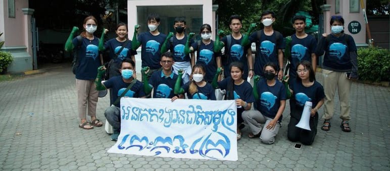 15 Jugendliche stehen und knien vor dem Gebäude des Tourismusministeriums und halten einen Banner in die Kamera. Dort steht: „Koh Kong Island soll ein Meeresnationalpark werden“