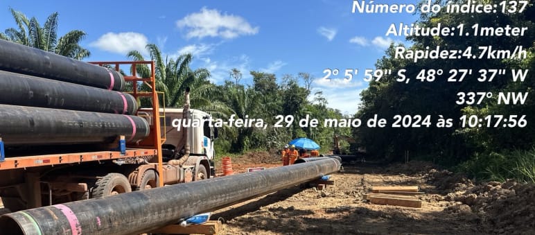 Sattelschlepper mit Pipelinerohrteilen, am Boden bereits abgelegte Rohrteile im Regenwald