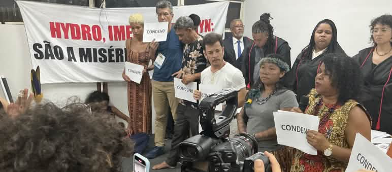 Eine Gruppe von zehn Personen, die das symbolische Gerichtsverfahren durchgeführt hat, wird mit einer Fotokamera und Handys gefilmt