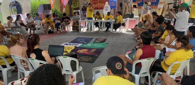 Etwa 30 Personen auf Stühlen bilden in einem Sitzungsraum einen Kreis