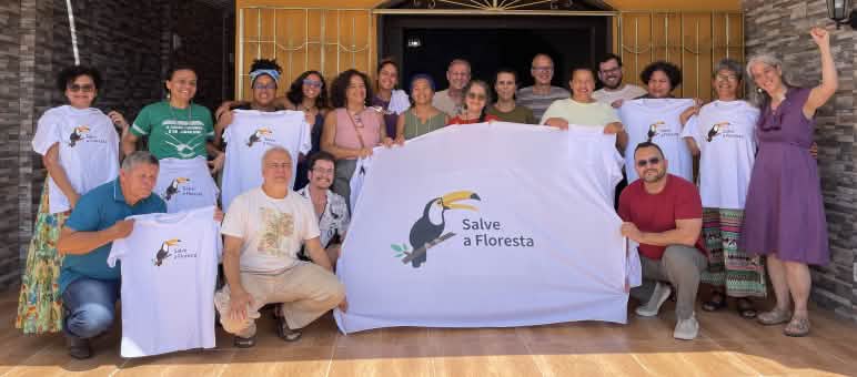 Gruppenfoto von 20 Personen mit einem Banner und T-Shirts mit dem Tukan-Logo des Vereins und der Aufschrift Salve a Floresta (Rettet den Regenwald)