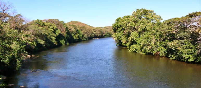 Blick auf eine Kurve des Santa Maria-Flusses mit Bäumen an beiden Ufern
