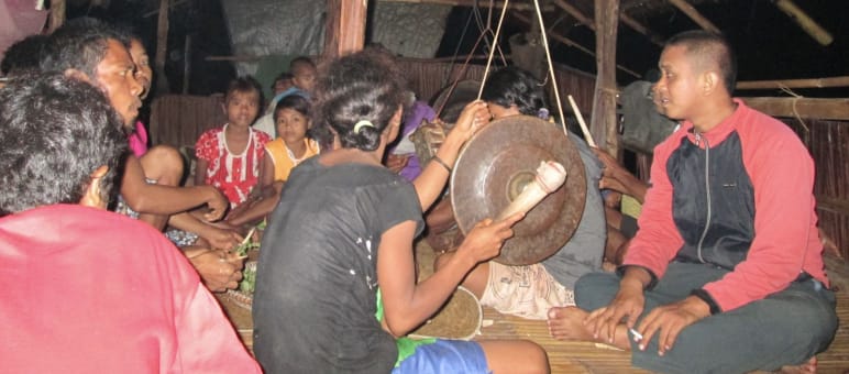 Gruppe Indigener mit Trommel in einer Hütte