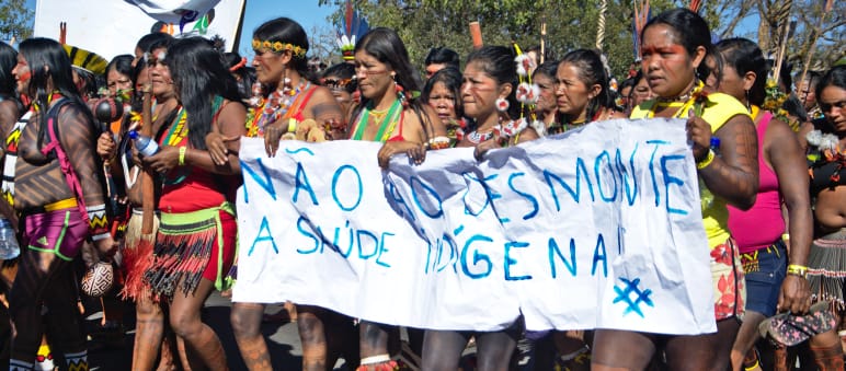Marsch und Demonstration indigener Frauen in Brasilia im Jahr 2020 gegen Abholzung und für die Gesundheitsversorgung der Indigenen Indigene Frauen in Brasilien protestieren mit einem Banner gegen die Abholzung ihrer Regenwald- und Schutzgebiete